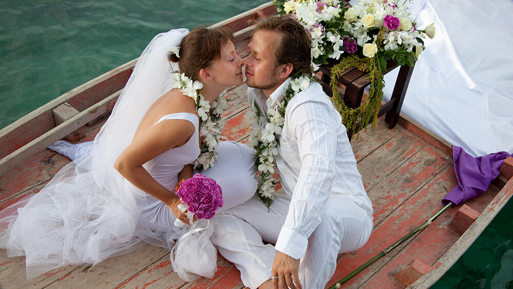 Married couple about to kiss on a little boat